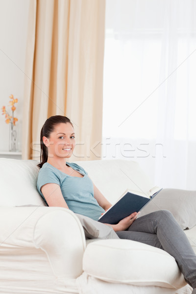 Vonzó nő olvas könyv ül kanapé nappali Stock fotó © wavebreak_media