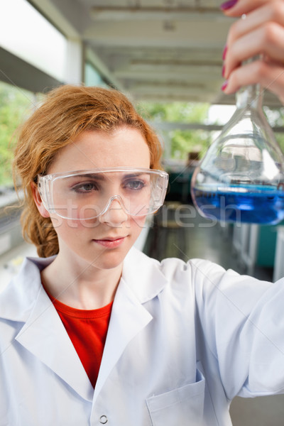 Portrait of a science student looking at a flask with protective glasses Stock photo © wavebreak_media