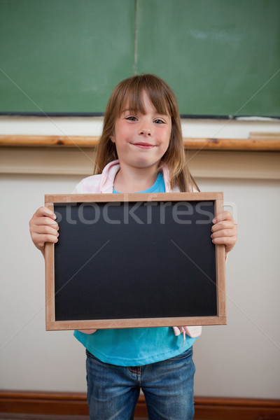 Portrait of a smiling girl holding a school slate in a classroom Stock photo © wavebreak_media