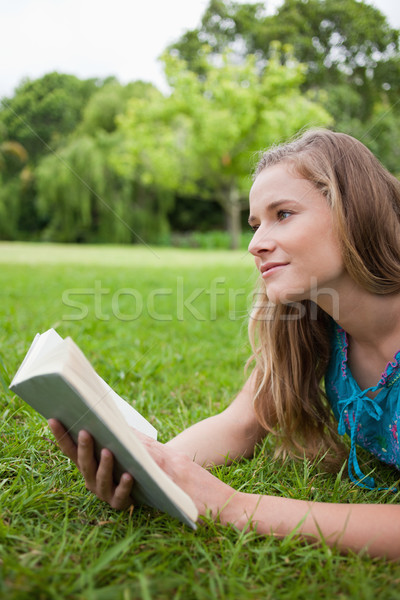 Figyelmes fiatal nő tart könyv másfelé néz fű Stock fotó © wavebreak_media
