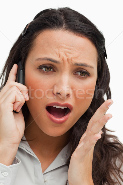Portrait of a brunette shocked while using her mobile against white background Stock photo © wavebreak_media