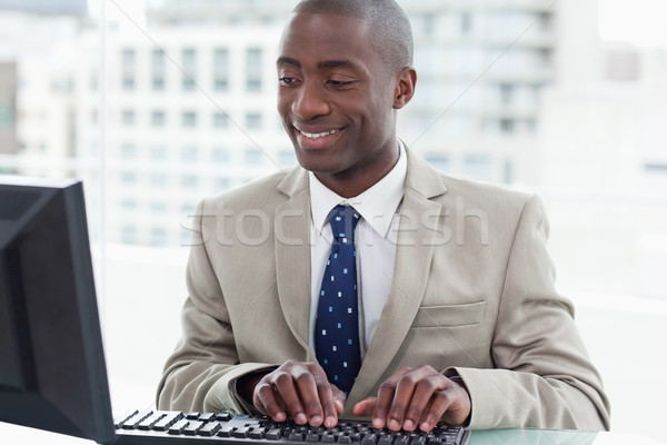 Smiling office worker using a computer in his office Stock photo © wavebreak_media