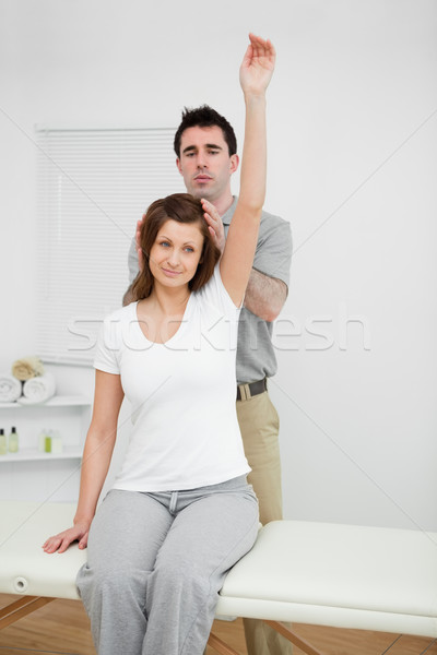 Peaceful woman raising her arm while being manipulated in a medical room Stock photo © wavebreak_media