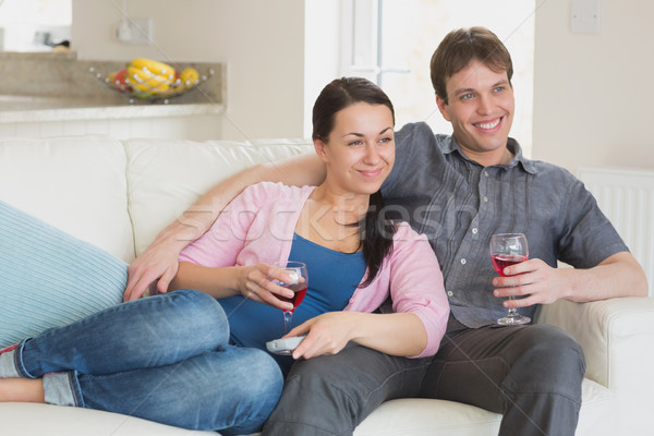 Stock photo: Young people sitting on the couch while watching television in the living room