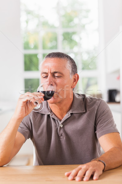 Homme vin rouge table de cuisine maison table [[stock_photo]] © wavebreak_media