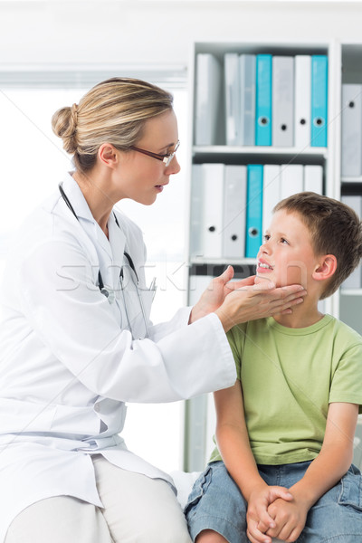Doctor examining thyroid gland of boy Stock photo © wavebreak_media