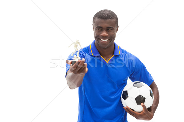 Football player in blue holding ball and figurine Stock photo © wavebreak_media