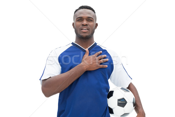 Football player in blue standing with the ball listening to anth Stock photo © wavebreak_media