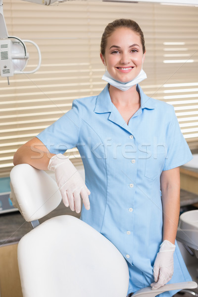 Dental assistant smiling at camera beside chair Stock photo © wavebreak_media
