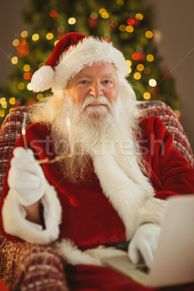 Sonriendo papá noel usando la computadora portátil sillón casa ordenador Foto stock © wavebreak_media