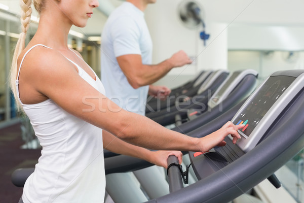 Side view mid section of couple running on treadmills at gym Stock photo © wavebreak_media