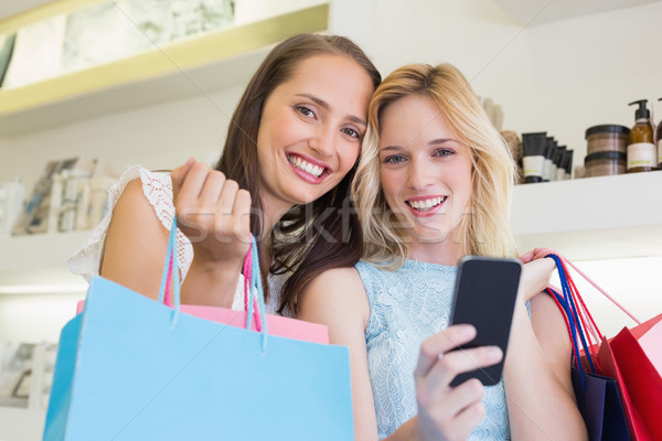 Heureux femmes souriant caméra smartphone [[stock_photo]] © wavebreak_media