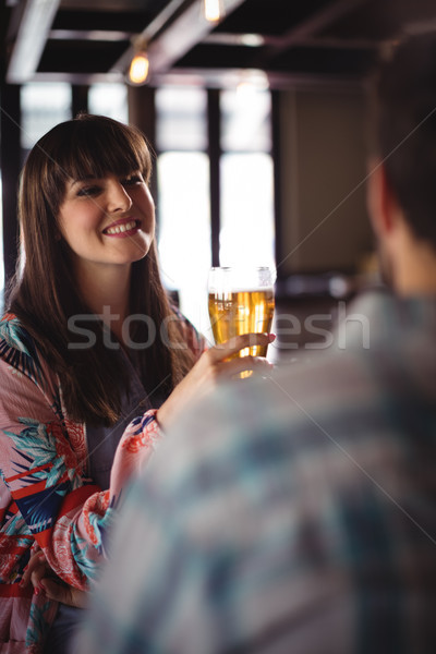 Happy couple interacting while having beer at counter Stock photo © wavebreak_media