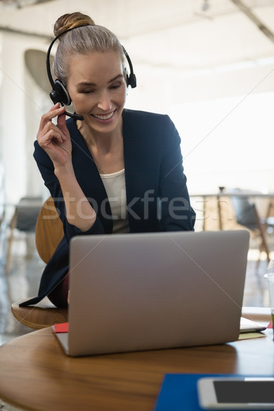 女實業家 說 耳機 使用筆記本電腦 表 辦公室 商業照片 © wavebreak_media