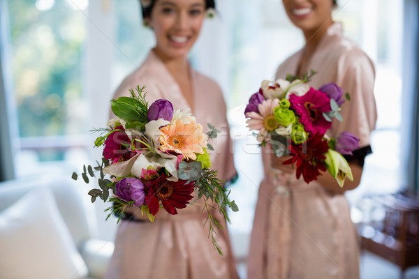 Happy brides holding bouquet Stock photo © wavebreak_media