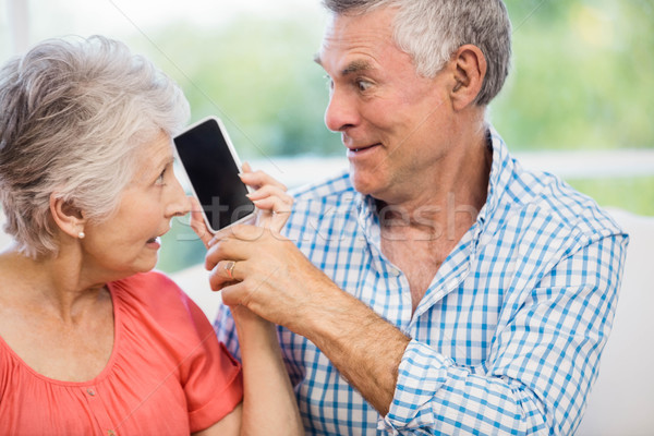 Happy senior couple listening to smartphone Stock photo © wavebreak_media