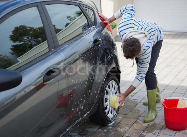 Auto service staff washing a car tyre with sponge Stock photo © wavebreak_media