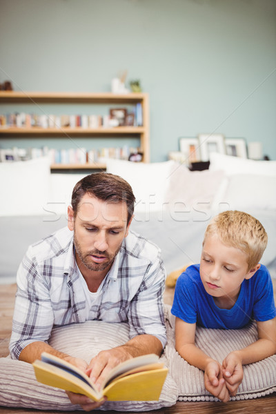 Close-up of father and son reading book while lying on floor Stock photo © wavebreak_media