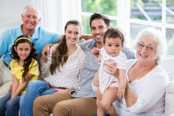 Portrait of cheerful family with baby while sitting on sofa Stock photo © wavebreak_media