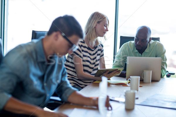 Colleagues interact at their desk using digital tablet and lapto Stock photo © wavebreak_media