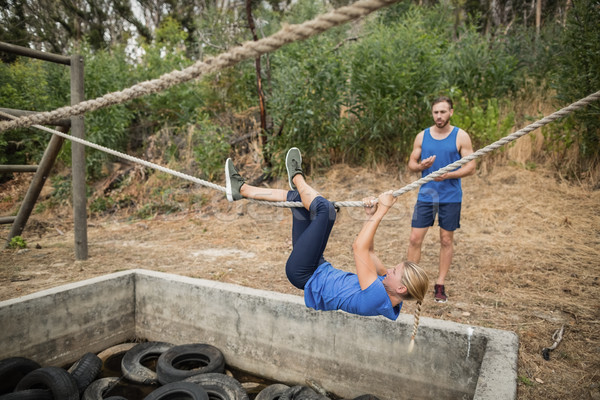 Woman climbing rope during obstacle course training Stock photo © wavebreak_media