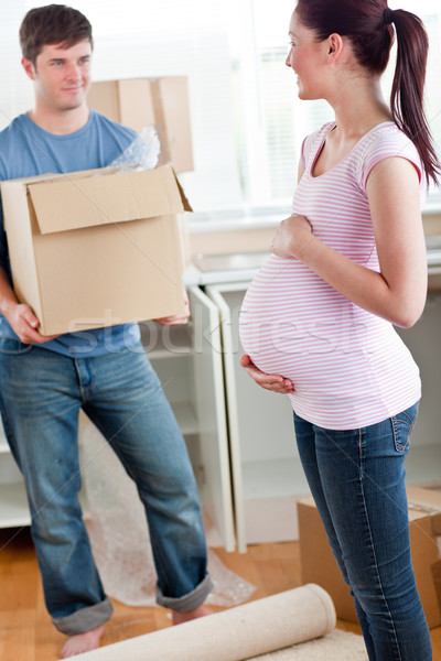 cute pregnant wife looking at her husband holding box standing in their new kitchen during removal Stock photo © wavebreak_media