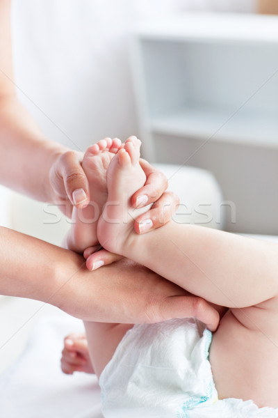 Caring young mother changing the diaper of her baby at home Stock photo © wavebreak_media