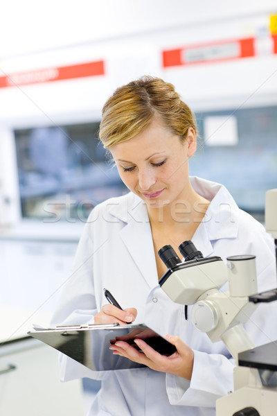 Grave femminile scienziato iscritto appunti microscopio Foto d'archivio © wavebreak_media