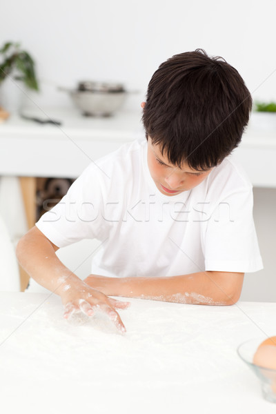 Cute boy playing with floor while cooking alone in the kitchen Stock photo © wavebreak_media
