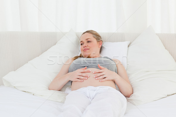 Beautiful woman with her hands on her belly at home Stock photo © wavebreak_media