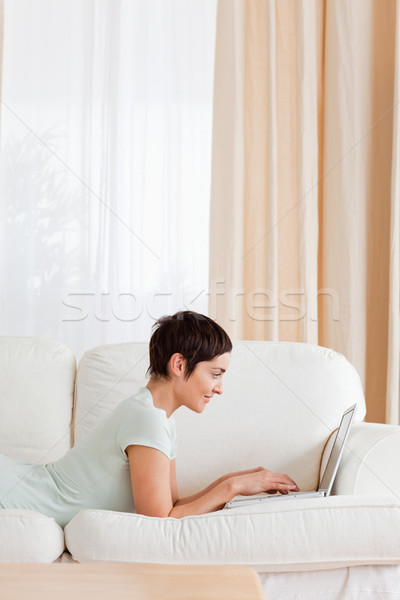 Portrait of a short-haired woman using a laptop in her living room Stock photo © wavebreak_media