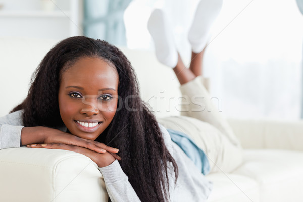 Smiling young woman lying on couch Stock photo © wavebreak_media