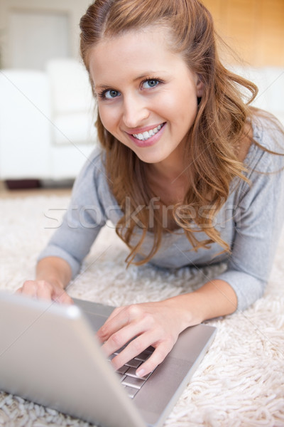 Jeune femme tapis surf internet ordinateur portable [[stock_photo]] © wavebreak_media