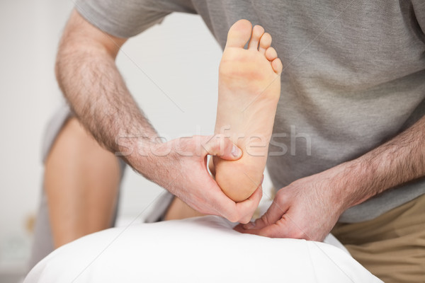 Doctor placing the foot of a patient on a pillow in his office Stock photo © wavebreak_media