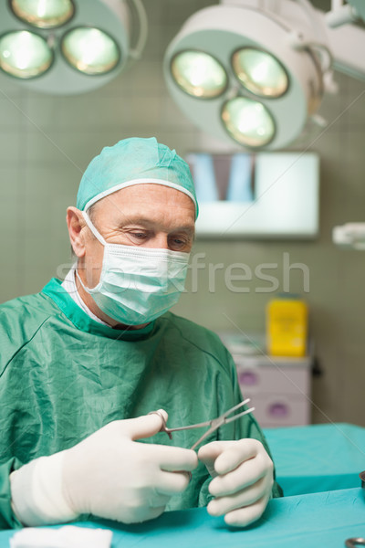 Surgeon holding scissors in a surgical room Stock photo © wavebreak_media