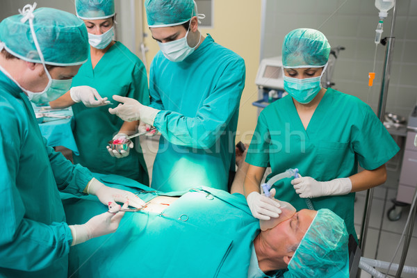 Nurse giving a surgical tool to a surgeon in an operating theatre Stock photo © wavebreak_media