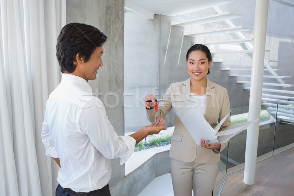 Estate agent giving house key to buyer Stock photo © wavebreak_media