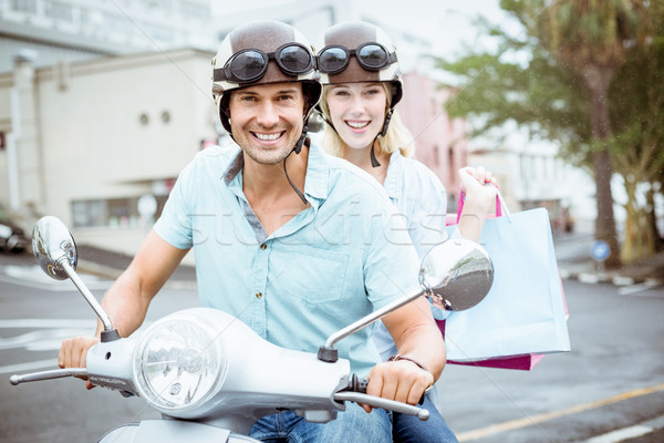 Hip young couple riding scooter with shopping bags Stock photo © wavebreak_media