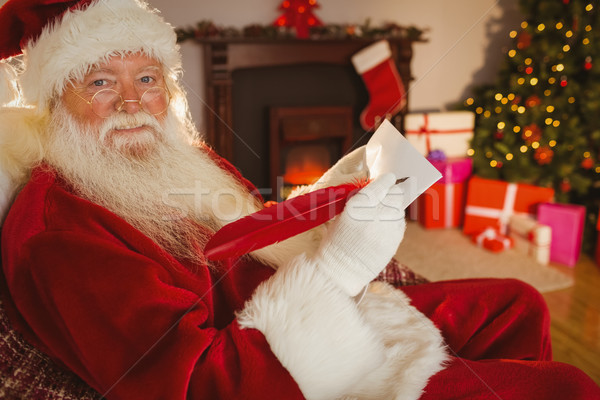 Smiling santa writing list with a quill Stock photo © wavebreak_media
