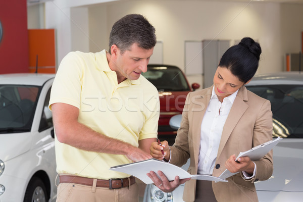 Salesperson talking with her customer while holding a booket Stock photo © wavebreak_media