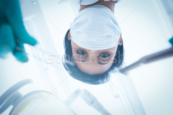 Female dentist in surgical mask holding dental tools Stock photo © wavebreak_media