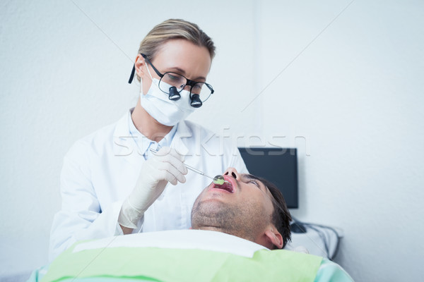 Femenino dentista examinar dientes dentistas silla Foto stock © wavebreak_media