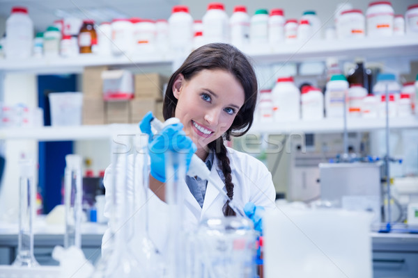 Smiling female scientist using a pipette Stock photo © wavebreak_media
