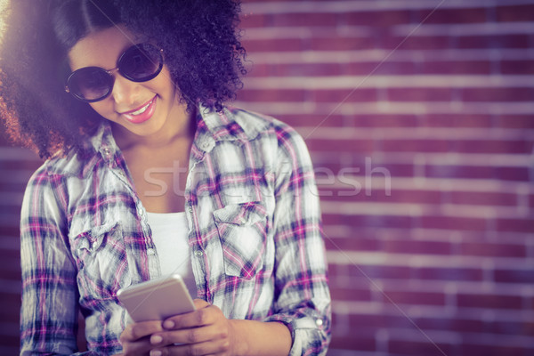 Attractive hipster with sunglasses texting Stock photo © wavebreak_media