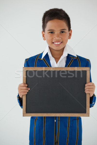 Schoolboy holding blank writing slate against white background Stock photo © wavebreak_media