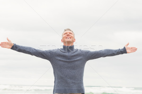 Man permanente armen uit breed strand Stockfoto © wavebreak_media