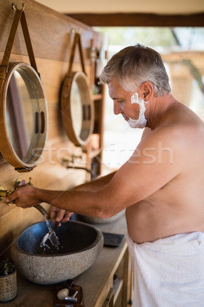 Man washing razor in cottage Stock photo © wavebreak_media