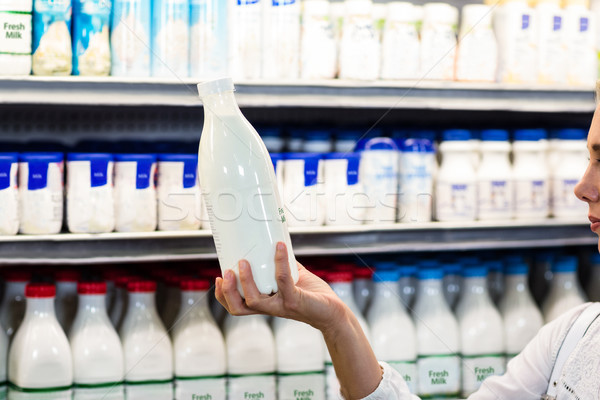 Stock photo: Beautiful woman holding milk bottle