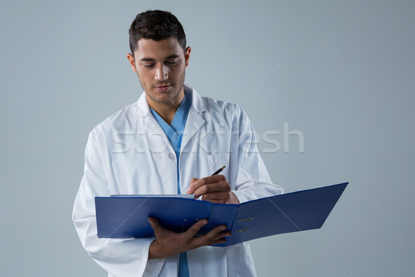Doctor writing a reports in the file Stock photo © wavebreak_media