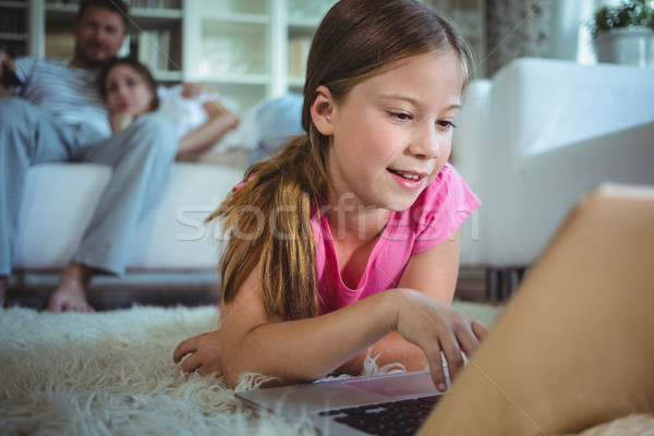 Stock photo: Girl lying on the floor and using laptop